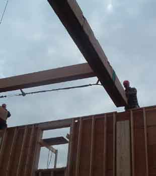 Picture of post created by 2 by stock.
This picture shows a post created by ganging up 2by stock together to support the load of the beam being lowered onto it.
