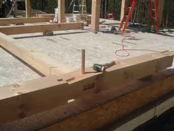 Large peg and mallet on bent being assembled.
This photos shows one of the wall posts of a bent being assembled on the deck. Here a 1 1/4" peg was used and next to it is a mallet.
